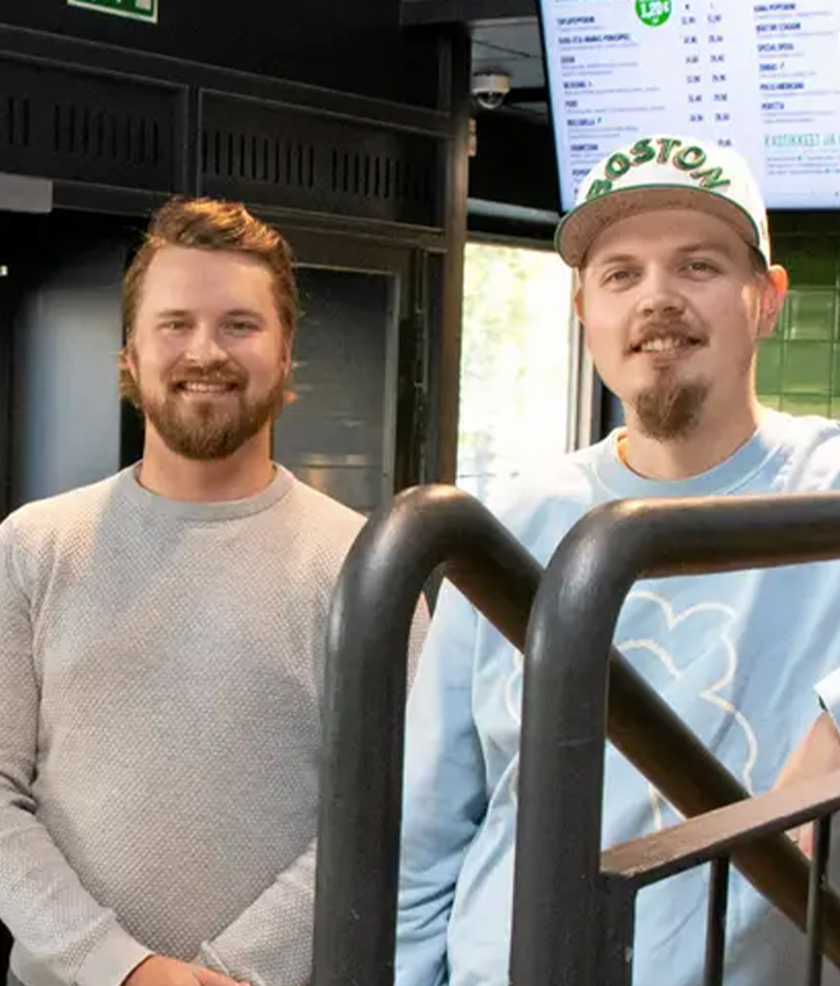 Kotipizza-ravintolan työntekijät hymyilevät kassan äärellä